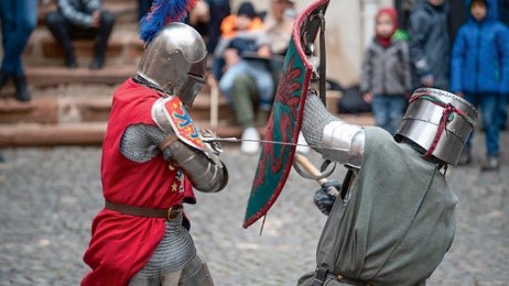 Menschen die sich als Ritter verkleidet haben und miteinander kämpfen